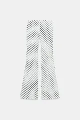 Pantalón flare stretch negro de tiro medio, con cintura elástica y botamanga acampanada.