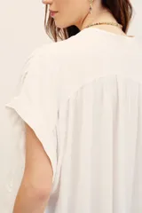 Camisa blanca de viscosa con cuello en V y mangas cortas de diseño holgado.