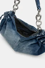 Bolso de hombro confeccionado en denim con efecto deslavado, diseño fruncido en los laterales con tiradores ajustables y asa de hombro combinada con cadena metálica plateada. Cuenta con cierre de cremallera y bolsillo interior.