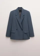 Blazer Uma de corte sastre en color azul acero, confeccionado en mezcla de lana, poliéster y elastano, con forro interior de viscosa. Presenta solapas de muesca, hombreras marcadas, bolsillos con solapa y cierre frontal de doble botonadura.