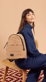 Mochila negra de tela capitoneada con bolsillo frontal amplio y asas ajustables. Incluye compartimento especial para iPad.