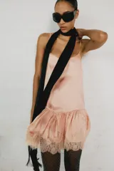 Vestido corto de estilo lencero, color rosado, con escote redondo, tirantes finos ajustables, bajo acabado en volante y detalles de encaje combinado a tono.