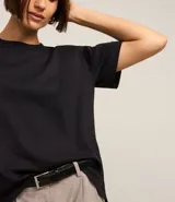 Blusa de manga corta confeccionada en algodón pima, con cuello redondo y diseño liso. Presenta un corte clásico con el bajo ligeramente más largo en la parte posterior.