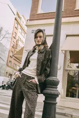 Sobrecamisa de silueta relajada con estampado animal print, cuello camisero, cierre frontal con botones y bolsillos aplicados.