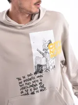 Buzo con capucha (canguro) color verde militar, corte holgado, con bolsillo canguro frontal y estampado gráfico en el pecho.