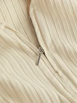 Sweater de punto acanalado color beige, con escote en V y cierre frontal completo. Presenta mangas largas y un diseño entallado.