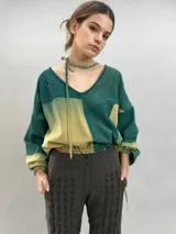 Pantalón tipo babucha confeccionado en lana de oveja, color visón. Presenta un diseño de tiro alto con textura vertical plisada a lo largo de las piernas, cintura con cierre de doble broche y puños elásticos en los tobillos.