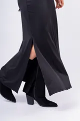 Vestido largo negro con escote halter, aberturas laterales y detalle de aros metálicos.