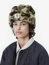 Gorro tipo beanie de Carhartt confeccionado en tejido de pelo sintético suave y texturado, con diseño de puño doblado y etiqueta tejida con el logo de la marca en el frente.
