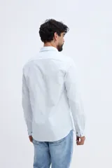 Camisa de manga larga fit semi slim color celeste, con cierre frontal de botones y cuello camisero clásico.