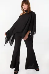 Blusa de lino italiano color negro, con diseño asimétrico de hombro descubierto y cuello tipo choker integrado, de manga larga amplia.