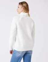 Polera de punto grueso color blanco, con cuello alto, mangas largas de corte ranglan y diseño de texturas combinadas.