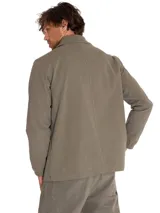 Chaqueta tipo coach de color verde oliva, con cierre frontal a presión, cuello camisero, puños elásticos y múltiples bolsillos frontales. Incluye etiqueta con logo de la marca en el pecho.