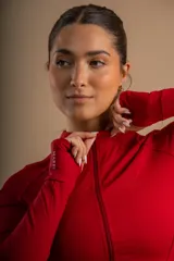 Campera deportiva roja con cierre frontal, cuello alto y bolsillos laterales.