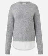 Suéter de punto jaspeado en color gris oscuro, con cuello redondo y mangas largas. Presenta un diseño integrado con una camisa blanca debajo, creando un efecto de capas superpuestas.
