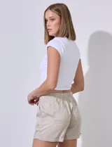 Short blanco de tencel marca Workshop, con pretina elastizada, fruncida y con lazo de ajuste. Delantera y trasera con bolsillos aplicados.