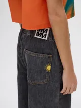 Pantalón de denim estilo jean relajado, de corte recto y holgado, con cintura elástica ajustable mediante cordón.