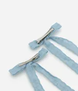 Par de pinzas para el pelo con diseño de lazo, confeccionadas en tela de encaje color celeste con detalles calados.