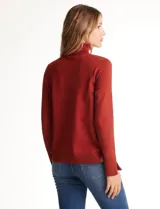 Polera de tejido fino, color rosado, con cuello alto, manga larga y detalle de tajo en los puños.