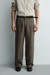 Pantalón straight fit color verde militar, confeccionado en lino, con cintura con trabillas, cierre frontal con cremallera y botón, y bolsillos laterales.