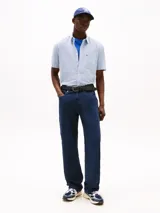 Camisa Tommy Jeans de corte regular, confeccionada en algodón mil rayas con textura. Diseño a rayas verticales celestes y blancas, con cuello abotonado, manga corta y bolsillo de parche en el pecho con logo de la marca.