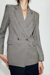 Blazer de corte entallado con estampado de pata de gallo, cuello solapa de muesca, manga larga con hombreras y cierre frontal cruzado con botones dorados. Cuenta con bolsillos con solapa en el delantero y forro interior a contraste.