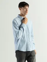 Camisa de manga larga color gris oscuro, confeccionada en algodón, con cuello clásico, cierre frontal con botones, bolsillo de parche en el pecho y corte clásico.