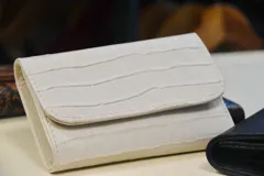 Billetera de cuero marrón con estampado de piel de serpiente, con cierre de broche a presión.