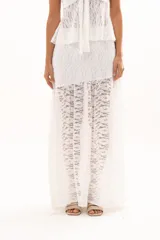 Pollera larga de encaje blanco con diseño de capas y transparencia, de corte fluido y estilo romántico.