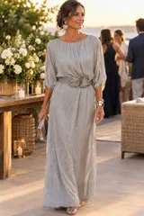 Vestido largo gris estilo túnica confeccionado en gasa, con mangas caídas y escote redondo fruncido. Incluye un cinturón ancho bordado con lentejuelas en forma de hojas.