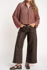 Sweater marrón de punto acanalado, con cuello alto, cierre frontal parcial con cremallera y manga larga.