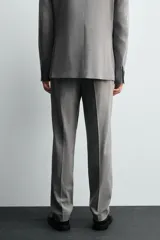 Pantalón de traje corte slim fit, color azul marino con textura sutil. Cuenta con bolsillos laterales, bolsillos traseros con botón y cierre frontal con cremallera y botón.