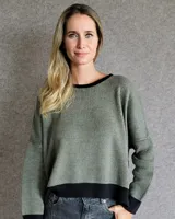 Buzo de punto con diseño de rayas verticales en tonos tostado y beige, con una estrella grande en la espalda y terminaciones en color verde oliva. Presenta un corte holgado y mangas anchas.