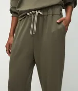 Pantalón tipo jogger de corte holgado con cintura elástica y cordón bicolor ajustable. Presenta puños elásticos en los tobillos y bolsillos laterales.