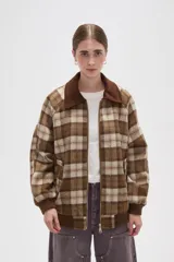 Campera de estilo bomber con cierre frontal, confeccionada en tejido a cuadros en tonos marrones y beige. Presenta cuello camisero en pana marrón, puños y ruedo elásticos acanalados, y bolsillos laterales.