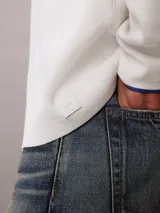 Sweater de punto técnico con corte boxy y cuello semi alto. Presenta un diseño minimalista de manga larga con puños en contraste y ajuste relajado.
