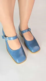 Guillerminas de cuero legítimo color azul, con puntera cuadrada, taco bajo de madera y tira con hebilla ajustable en el empeine.