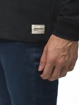 Remera de manga larga con cuello redondo, confeccionada en algodón, de corte clásico y diseño minimalista con detalle de etiqueta pequeña en el ruedo.