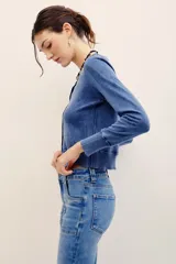 Cardigan de punto con efecto denim, cuello redondo, cierre frontal con botones y mangas largas con puños acanalados.