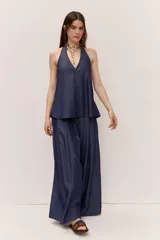 Pantalón de pierna ancha color azul, con pliegues frontales y caída suave.