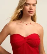 Vestido midi de punto acanalado color rojo, sin breteles, con escote corazón torcido y abertura en la espalda.