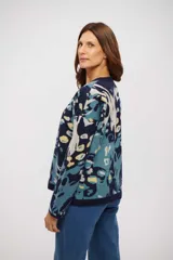 Buzo de tejido de punto con diseño estampado abstracto en tonos azul marino, celeste y amarillo. Presenta cuello redondo, mangas largas y terminaciones en tejido acanalado.