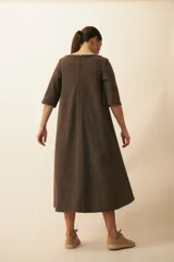 Vestido midi acampanado de lana fina sin teñir, con cuello bote, mangas tres cuartos con tajo y bolsillos laterales. Diseño forrado con vuelo y movimiento.