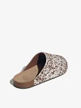 Sandalias Adidas Adimule tipo mule, con diseño slip-on, capellada de cuero con estampado tipo animal print de manchas marrones sobre fondo blanco, suela de corcho y base de goma.