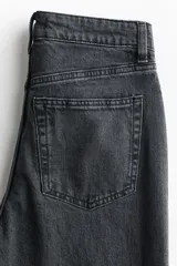 Jean de tiro alto con corte wide leg, confeccionado en denim de algodón con leve elasticidad. Presenta diseño clásico de cinco bolsillos, cierre frontal con botón y pernera amplia.
