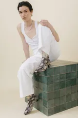 Botín blanco con estampado de piel de serpiente, punta fina y taco chupete. Cierre con cremallera en la parte trasera.