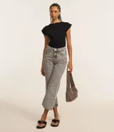 Top ajustado color rojo, con cuello redondo y mangas cortas tipo hombreras o almohadillas. El tejido parece ser de punto o viscosa con buena caída y presenta un fruncido horizontal a la altura de la cintura.