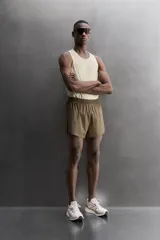 Short de running confeccionado en tejido técnico ligero y elástico con estructura. Cuenta con forro interior, cintura elástica ajustable con cordón, bolsillo trasero con cierre oculto, bolsillos laterales multifunción y aberturas laterales en las perneras.