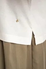 Remera blanca con mangas cortas abullonadas de encaje con diseño perforado, cuello redondo y corte oversize.