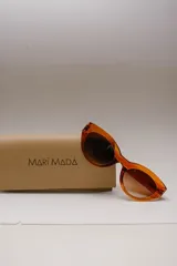 Lentes de sol ovalados con montura de acetato color naranja y lentes marrones degradados. Ofrecen protección UVA/UVB.